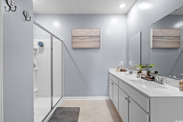 bathroom with tile patterned flooring, double vanity, a sink, baseboards, and a stall shower