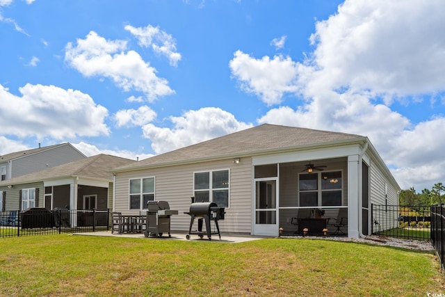 back of house with a sunroom, a lawn, a patio area, and fence