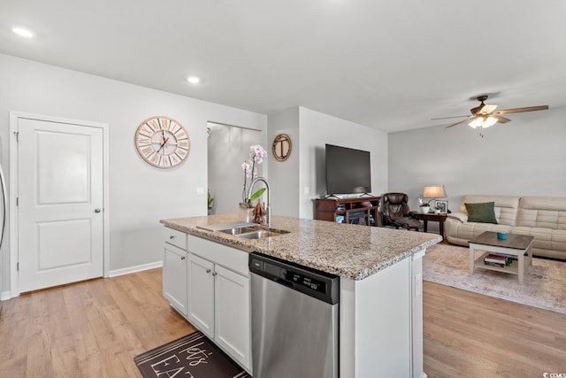 kitchen featuring stainless steel dishwasher, a sink, white cabinets, and light wood-style flooring