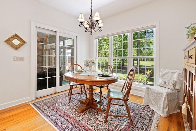 dining area featuring a chandelier, baseboards, and light wood-style flooring