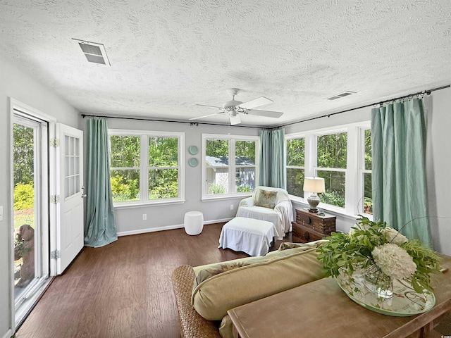 sunroom featuring wood finished floors, visible vents, and a textured ceiling