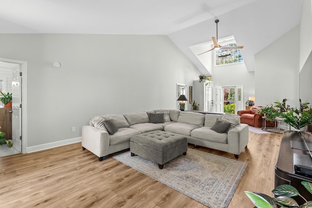 living room with high vaulted ceiling, light wood finished floors, baseboards, and ceiling fan