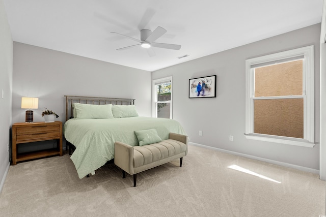 bedroom with visible vents, baseboards, ceiling fan, and light carpet