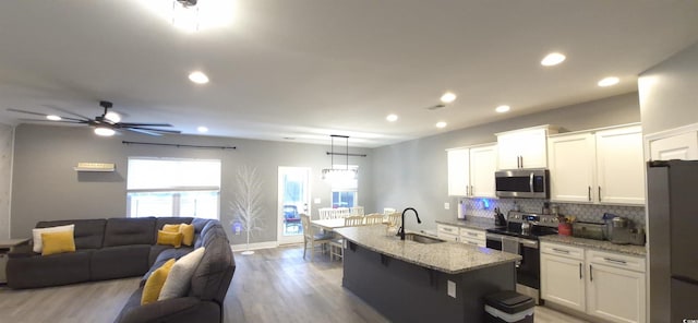 897 Wild Leaf Loop, Conway, SC 29526 - kitchen with stainless steel appliances, open floor plan, light wood-style floors, decorative backsplash, and a breakfast bar area