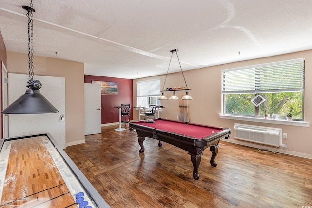 recreation room featuring a textured ceiling, wood finished floors, a wall mounted air conditioner, billiards, and baseboards