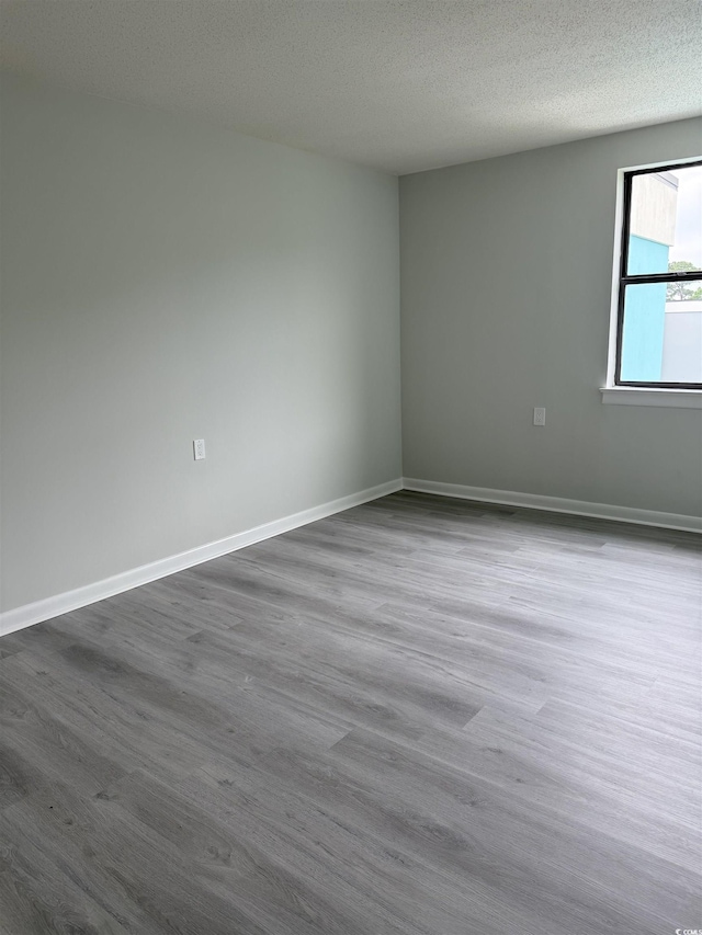 5001 Little River Rd Unit 501E, Myrtle Beach, SC 29577 - spare room featuring dark wood-type flooring, a textured ceiling, and baseboards