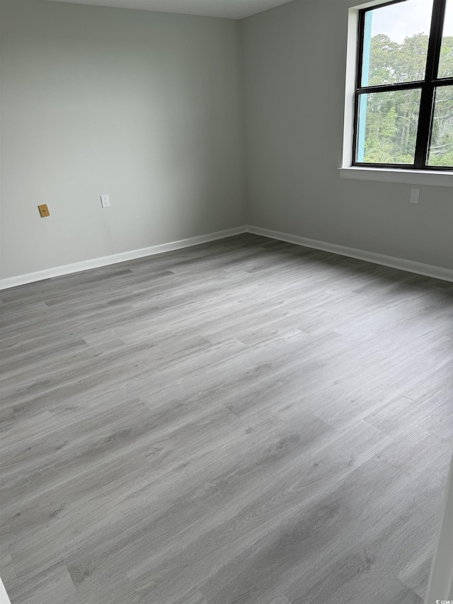 unfurnished room with baseboards and wood finished floors