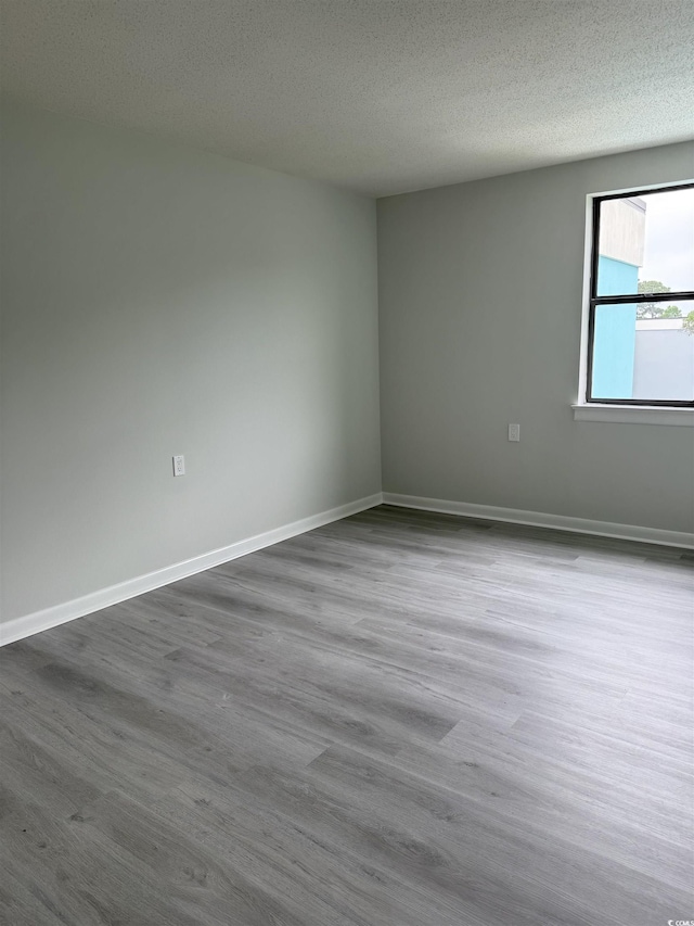5001 Little River Rd Unit 501E, Myrtle Beach, SC 29577 - spare room with dark wood-style flooring, a textured ceiling, and baseboards