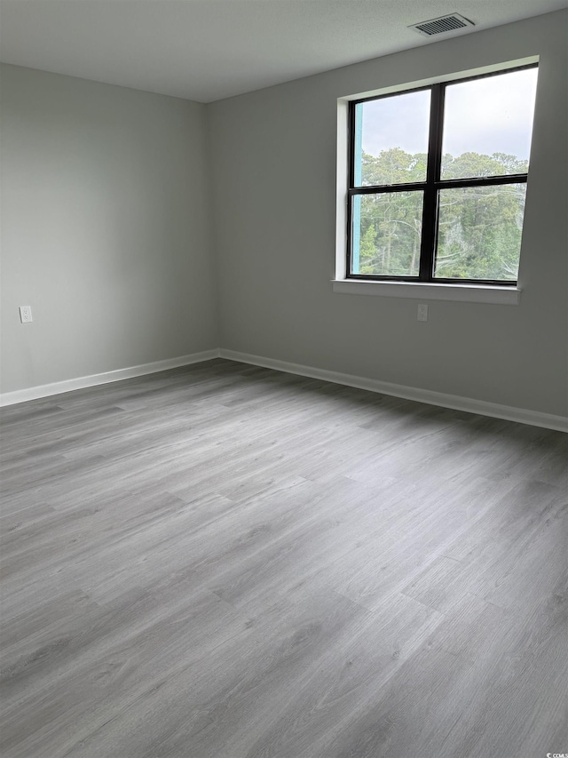 empty room with baseboards and wood finished floors