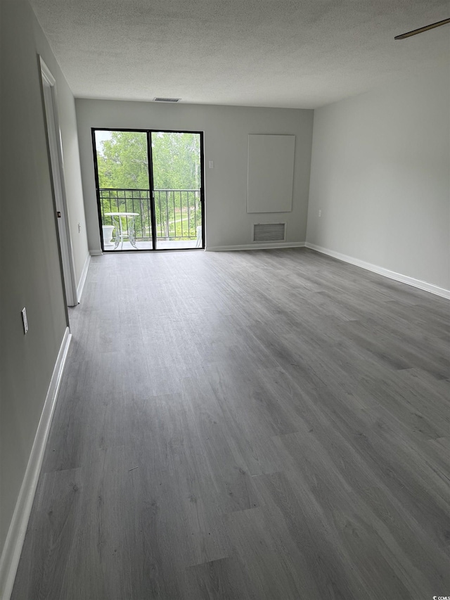 5001 Little River Rd Unit 501E, Myrtle Beach, SC 29577 - unfurnished living room featuring wood finished floors, baseboards, and a textured ceiling