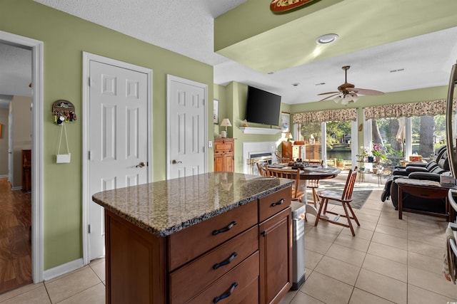 111 Cedar Ridge Ln, Conway, SC 29526 - kitchen with ceiling fan, light tile patterned floors, dark stone counters, baseboards, and a kitchen island