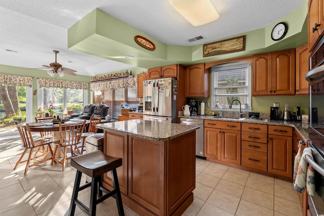 111 Cedar Ridge Ln, Conway, SC 29526 - kitchen with appliances with stainless steel finishes, a textured ceiling, a kitchen island, a sink, and a ceiling fan
