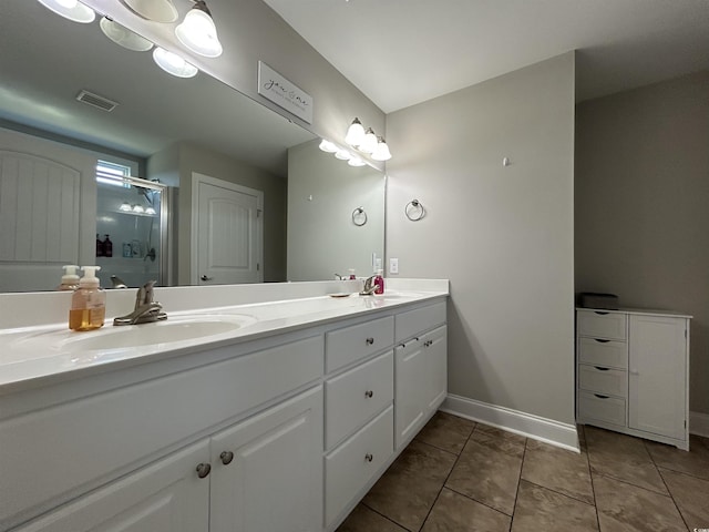 bathroom featuring double vanity, a shower stall, baseboards, and tile patterned floors