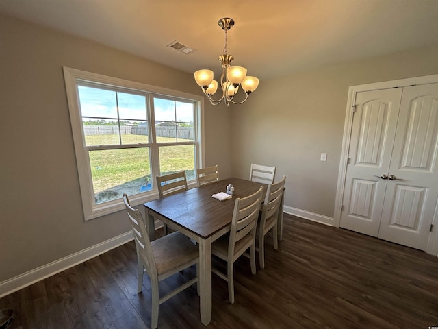 dining space featuring a chandelier, dark wood-type flooring, and baseboards