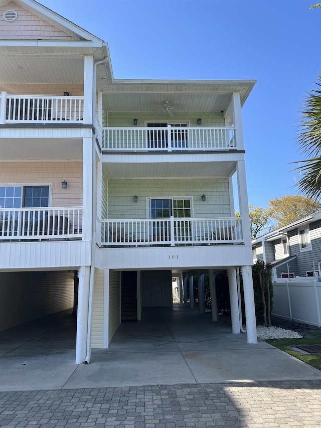 1516 Edge Dr Unit 101, North Myrtle Beach, SC 29582 - view of front of property featuring fence, driveway, a balcony, and a carport