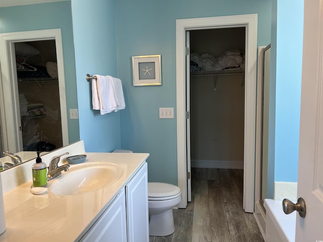 1516 Edge Dr Unit 101, North Myrtle Beach, SC 29582 - bathroom with vanity, a walk in closet, wood finished floors, and toilet