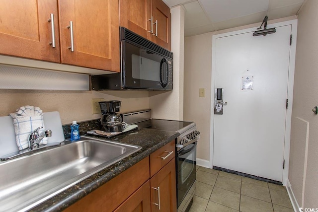 1200 N Ocean Blvd N Unit 905, Myrtle Beach, SC 29577 - kitchen with stainless steel electric stove, black microwave, brown cabinets, light tile patterned floors, and dark countertops