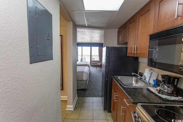1200 N Ocean Blvd N Unit 905, Myrtle Beach, SC 29577 - kitchen with electric panel, a textured wall, brown cabinetry, black appliances, and light tile patterned flooring