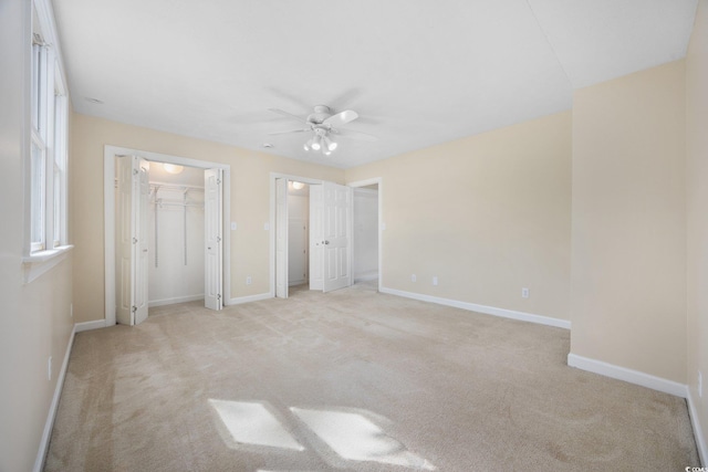 unfurnished bedroom with light carpet, baseboards, and a ceiling fan