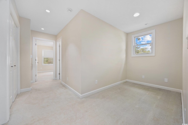 corridor featuring light colored carpet, baseboards, and recessed lighting