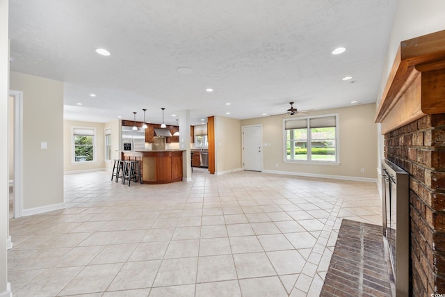 unfurnished living room with a fireplace, light tile patterned flooring, plenty of natural light, and recessed lighting