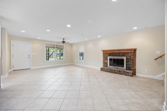 unfurnished living room featuring ceiling fan, light tile patterned floors, a brick fireplace, recessed lighting, and baseboards