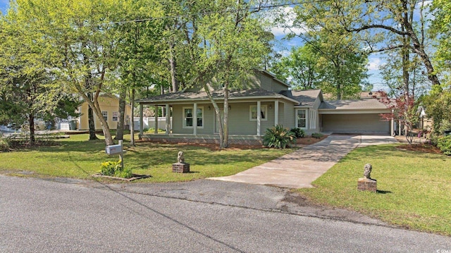 view of front facade featuring driveway, a front yard, and covered porch