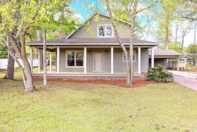 country-style home with a porch, a front yard, concrete driveway, and a shingled roof