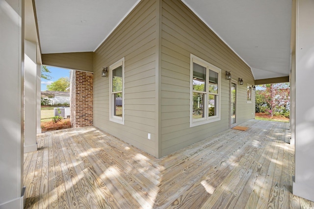 wooden deck with a porch and cooling unit