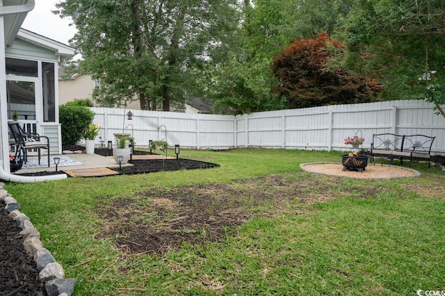 view of yard featuring a fire pit and a sunroom