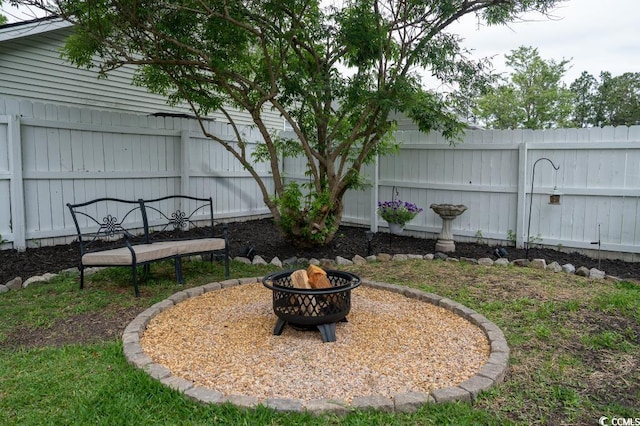 fenced backyard with a fire pit