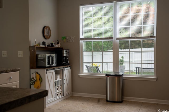 dining area with baseboards and light tile patterned flooring