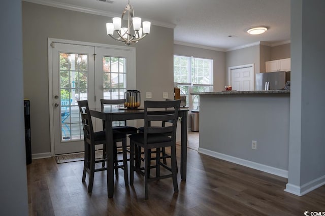 dining room featuring a chandelier, crown molding, dark wood-style flooring, and baseboards