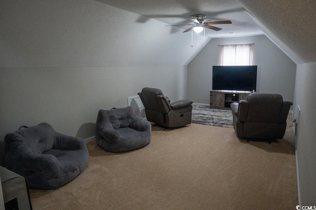 sitting room with carpet flooring, ceiling fan, lofted ceiling, and a textured ceiling