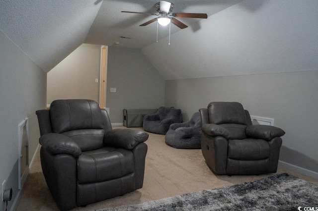 living area with carpet flooring, ceiling fan, vaulted ceiling, baseboards, and a textured ceiling