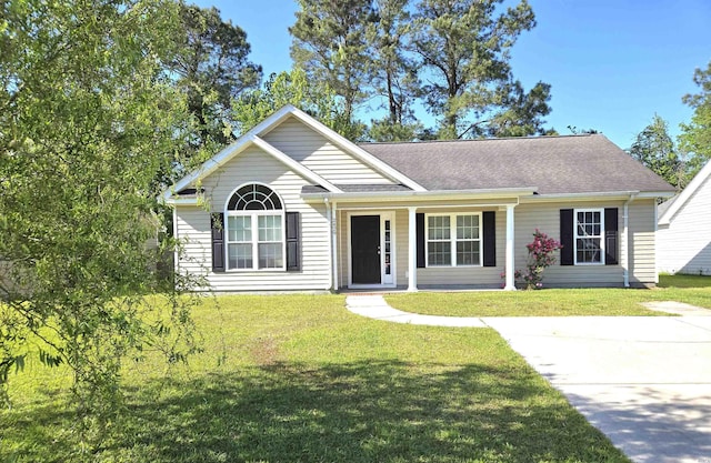 view of front of home featuring a front lawn, a shingled roof, and covered porch