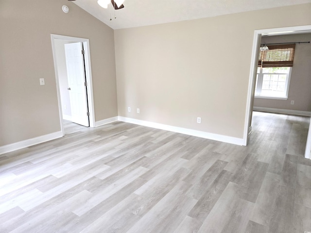 unfurnished room featuring lofted ceiling, a ceiling fan, light wood finished floors, and baseboards