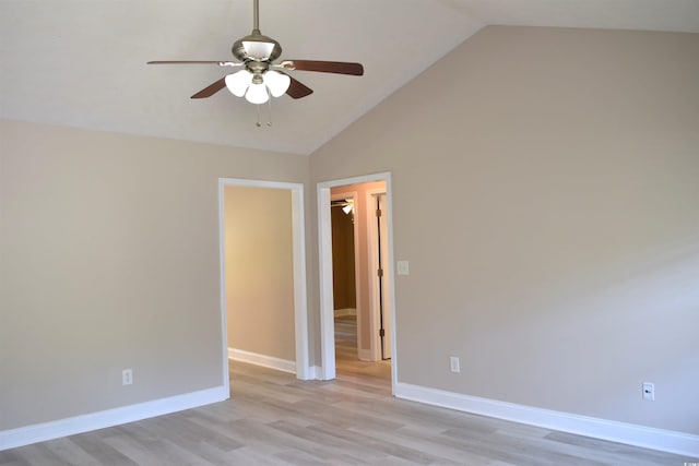 spare room with a ceiling fan, baseboards, vaulted ceiling, and light wood-type flooring