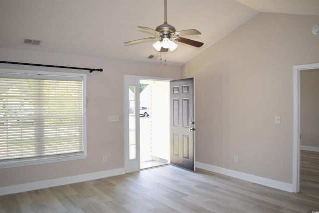 foyer entrance featuring visible vents, ceiling fan, light wood-type flooring, and vaulted ceiling