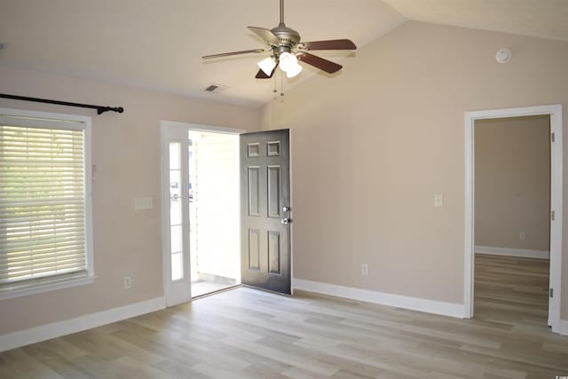 foyer entrance with light wood finished floors, ceiling fan, visible vents, and vaulted ceiling