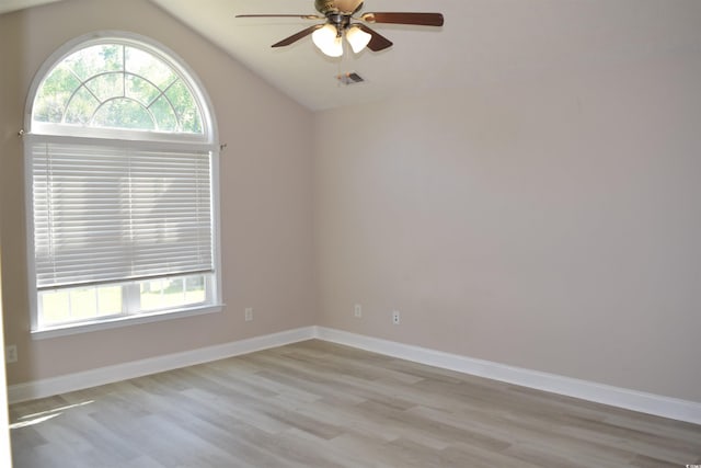 empty room with baseboards, light wood-type flooring, ceiling fan, and lofted ceiling