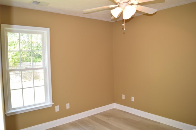 unfurnished room featuring light wood finished floors, visible vents, ceiling fan, and plenty of natural light