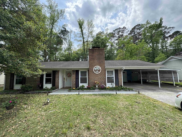 single story home featuring a carport, a chimney, concrete driveway, brick siding, and a front yard