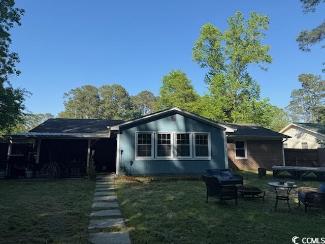 back of house featuring a fire pit and a yard
