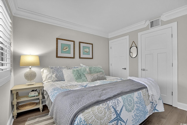 bedroom with visible vents, baseboards, crown molding, and wood finished floors