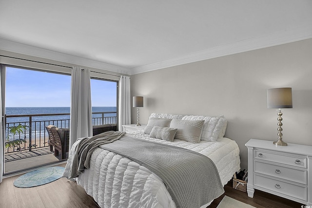 bedroom featuring crown molding, a water view, wood finished floors, and access to exterior