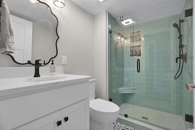 bathroom with vanity, tile patterned flooring, a shower stall, and toilet