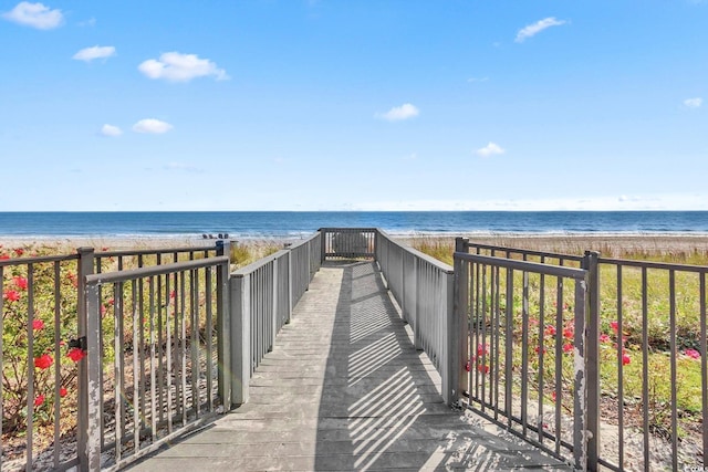 view of community with a water view and a beach view
