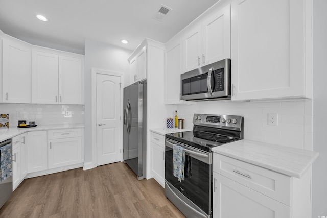 5132 Little River Neck Rd, North Myrtle Beach, SC 29582 - kitchen with light wood finished floors, stainless steel appliances, white cabinetry, visible vents, and tasteful backsplash