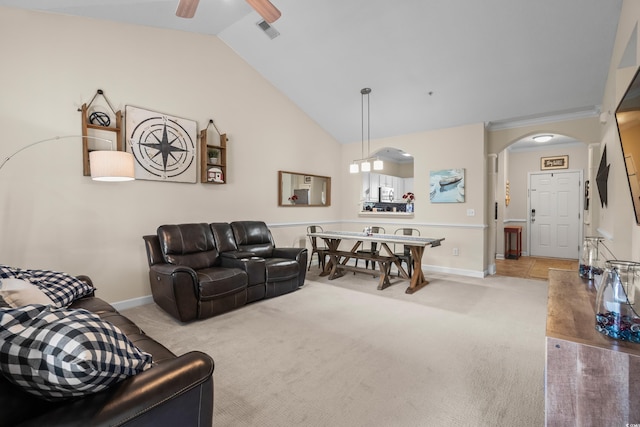 carpeted living area with arched walkways, ceiling fan, lofted ceiling, and baseboards